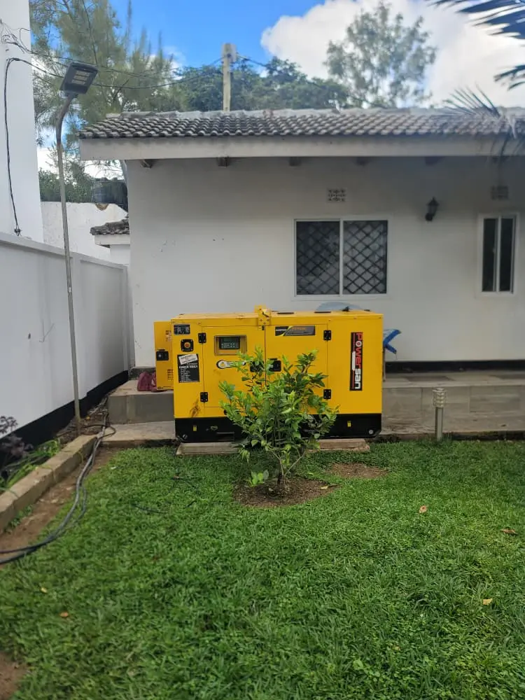 Yellow enclosed generator installed beside a residence